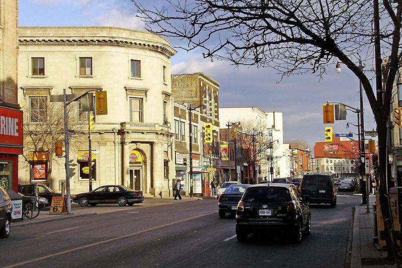 Looking east along Dundas Street West at Keele Street in the Junction, Toronto, with older commercial buildings and traffic